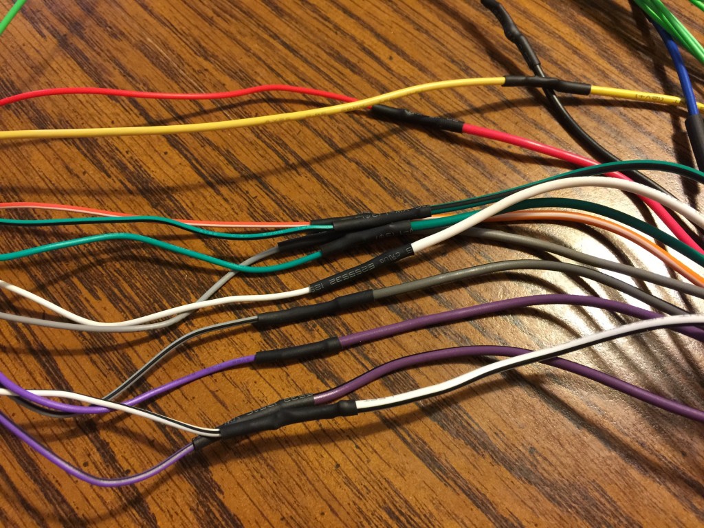 The wires were first stripped and tinned with 60/40 solder. Next the tinned ends of the wires were overlapped, and a minimal amount of solder fused the wires together. Precut heat-shrinking sleeves were used as insulation.  Very clean. Very professional. 